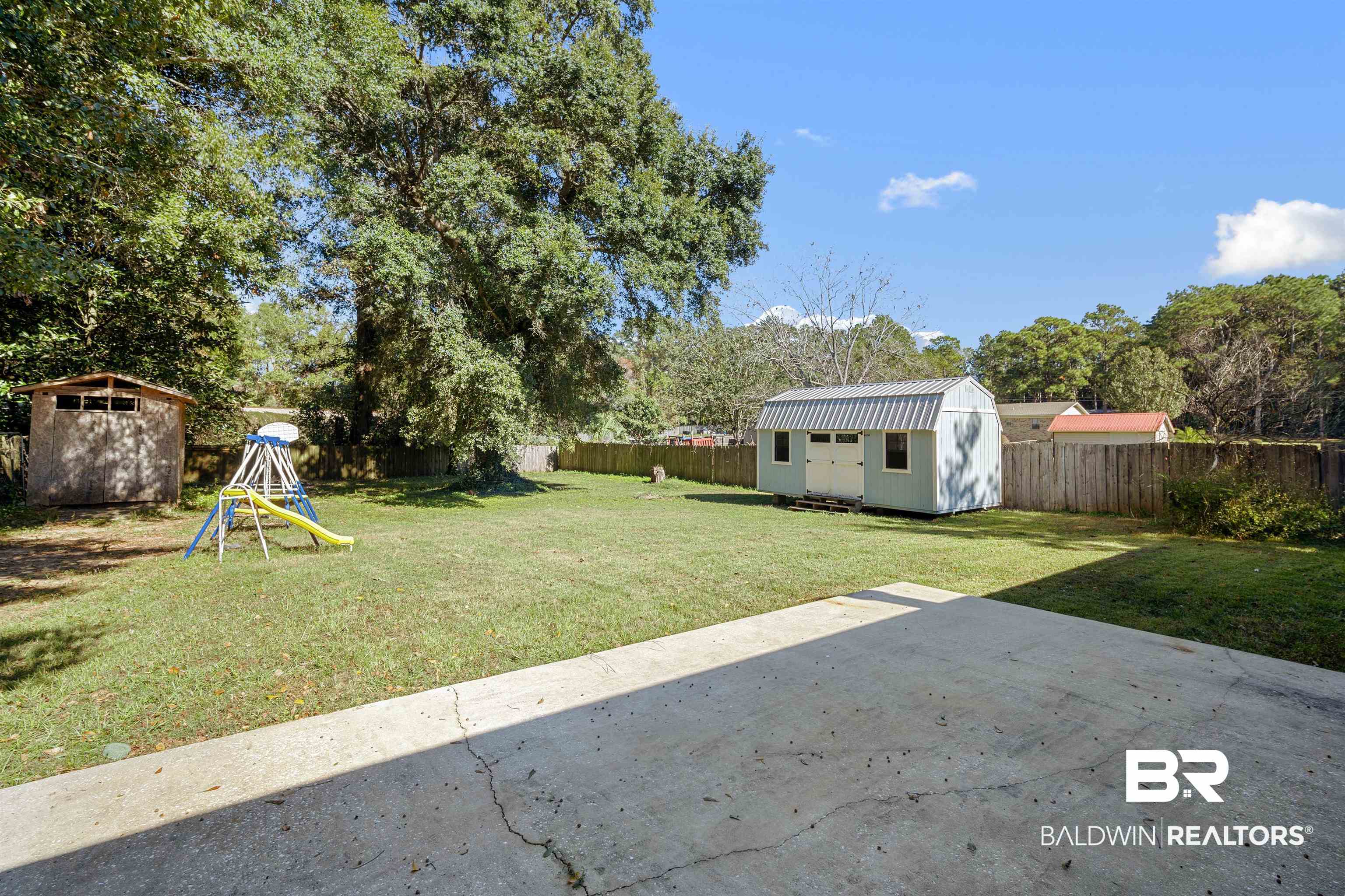 12910 Del Rio Street Grand Bay, AL 36541 - Photo 25 of 26 Fenced backyard featuring a shed, a patio, and view of scattered trees