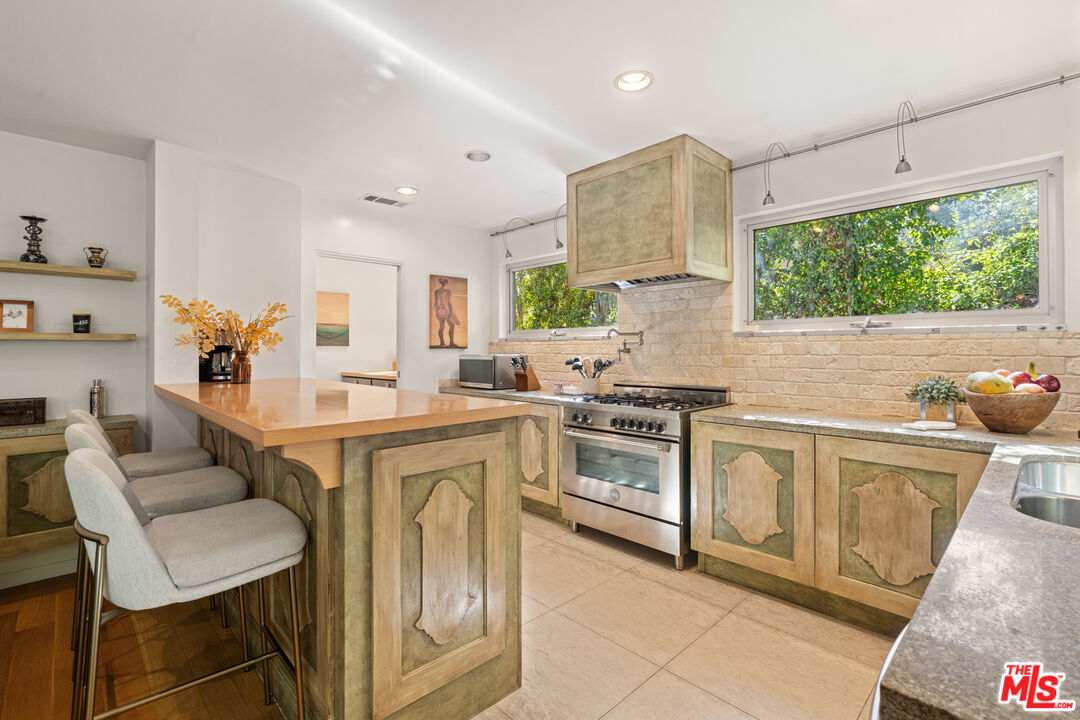 1853 Nichols Canyon Road Los Angeles, CA 90046 - Photo 12 of 48 a open kitchen with stainless steel appliances granite countertop a stove a sink and a microwave