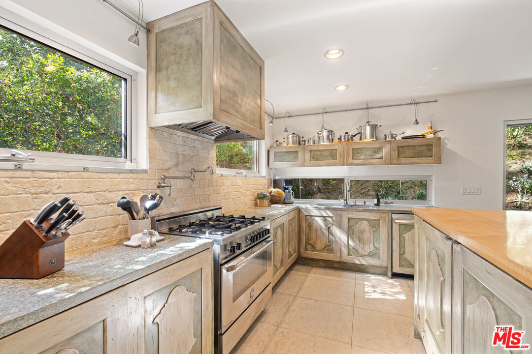 1853 Nichols Canyon Road Los Angeles, CA 90046 - Photo 13 of 48 a kitchen with stainless steel appliances a sink a stove and cabinets