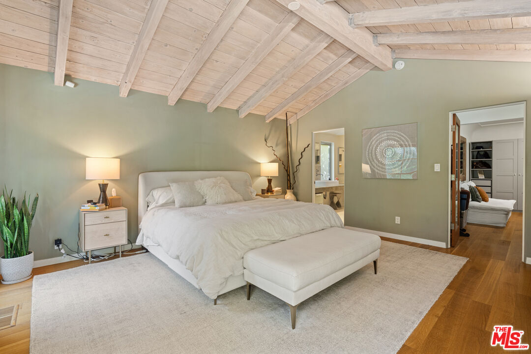 1853 Nichols Canyon Road Los Angeles, CA 90046 - Photo 18 of 48 a spacious bedroom with a bed a table and potted plant