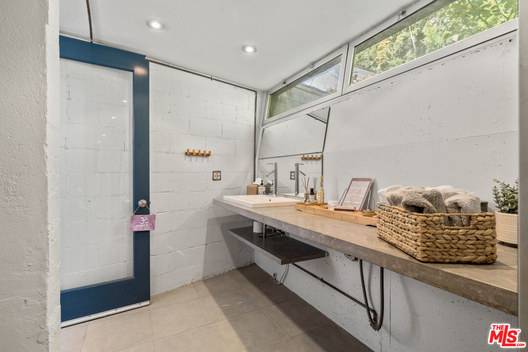 1853 Nichols Canyon Road Los Angeles, CA 90046 - Photo 34 of 48 a bathroom with a granite countertop sink and a mirror