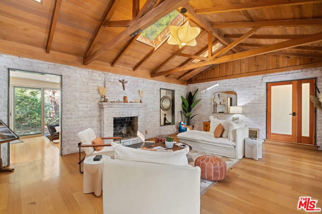 1853 Nichols Canyon Road Los Angeles, CA 90046 - Photo 9 of 48 a living room with furniture a fireplace and wooden floor