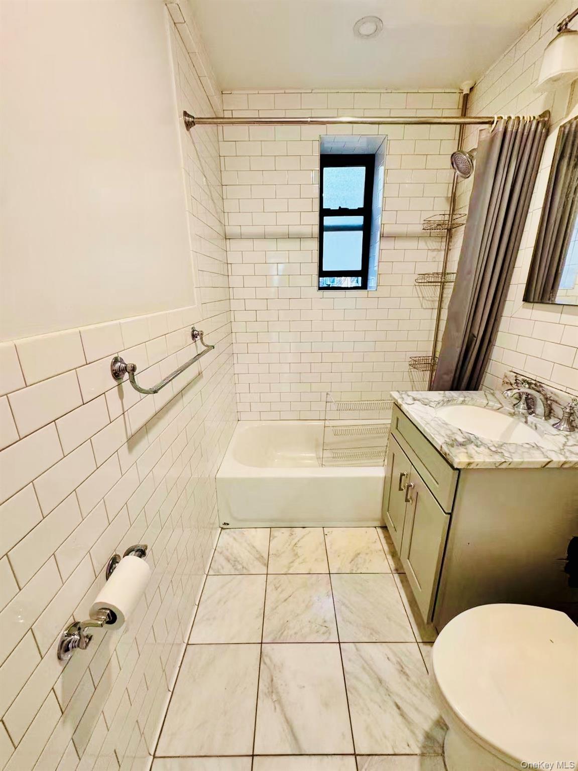 44-05 Macnish Street, Unit 2G Queens, NY 11373 - Photo 3 of 12 Bathroom featuring tile walls, shower / bath combo, vanity, and light tile patterned flooring