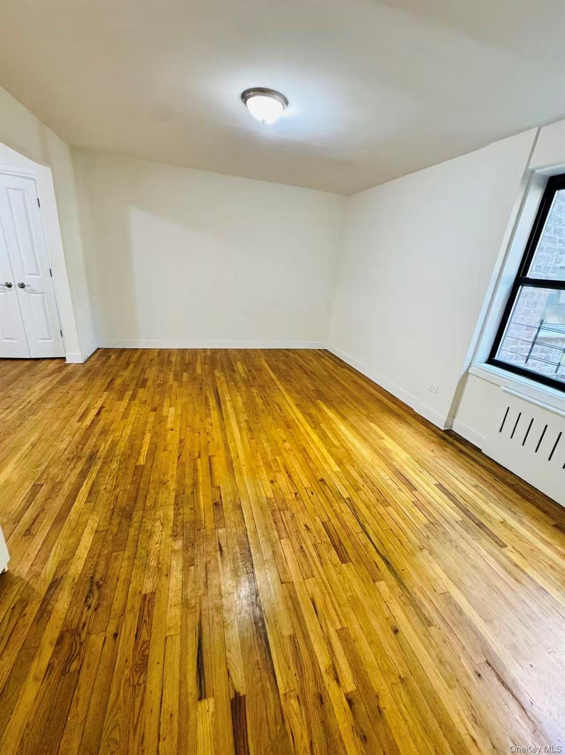 44-05 Macnish Street, Unit 2G Queens, NY 11373 - Photo 4 of 12 Empty room featuring light wood finished floors and baseboards