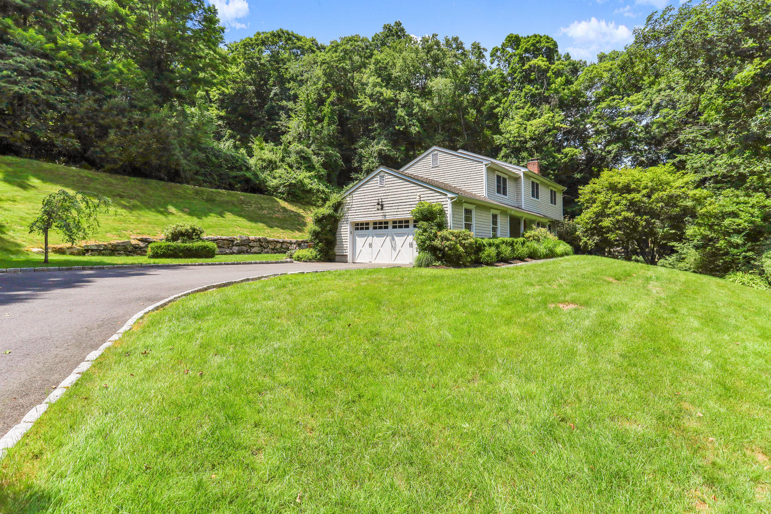 704 Valley Road New Canaan, CT 06840 - Photo 2 of 59 a front view of a house with yard and green space