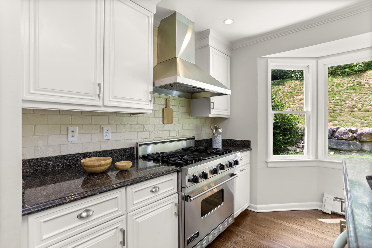 704 Valley Road New Canaan, CT 06840 - Photo 18 of 59 a kitchen with granite countertop a stove and a white cabinets
