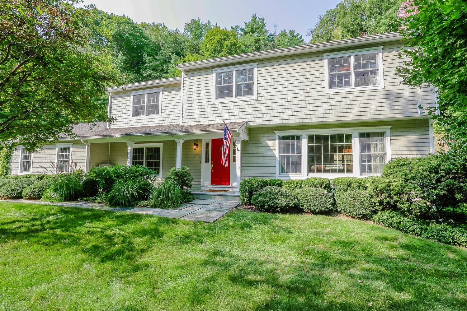 704 Valley Road New Canaan, CT 06840 - Photo 3 of 59 a view of a house with a yard and plants