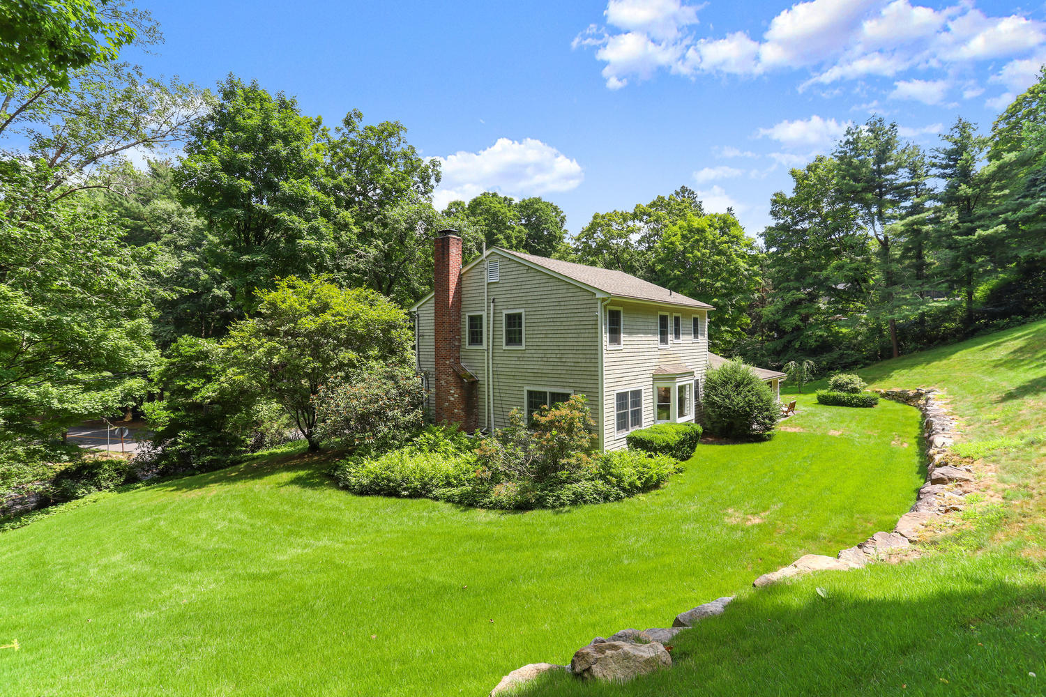 704 Valley Road New Canaan, CT 06840 - Photo 54 of 59 a yellow house with garden in front of it