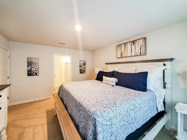 a bedroom with a large bed and a chandelier