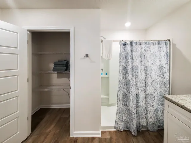 a view of walk in closet with wooden floor