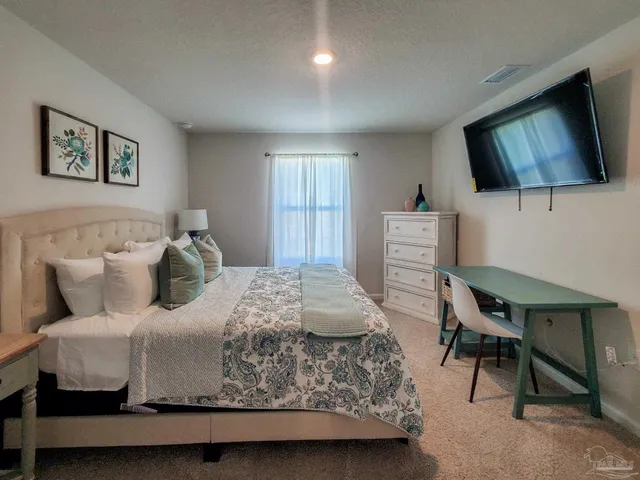 a bedroom with a bed window and a flat screen tv