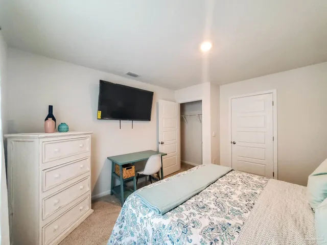 a bedroom with a bed and a flat screen tv