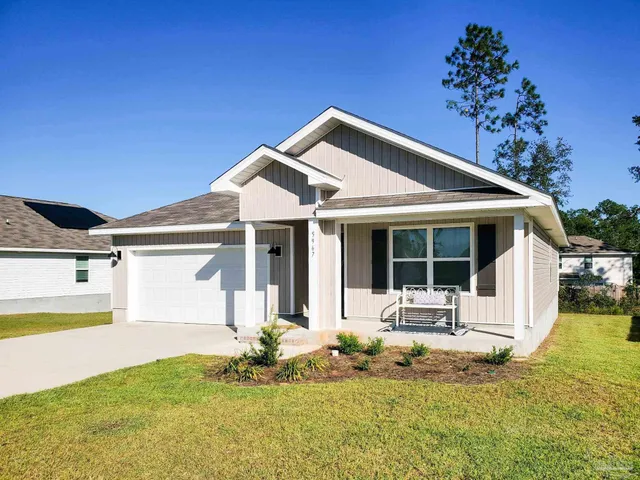 a front view of a house with a garden and yard