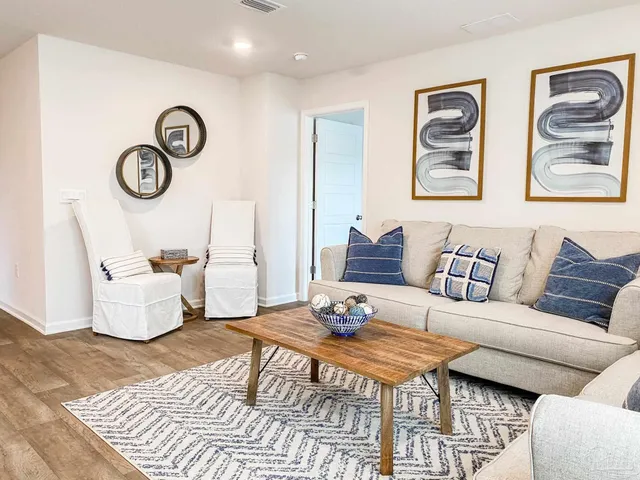 a living room with furniture and a wooden floor