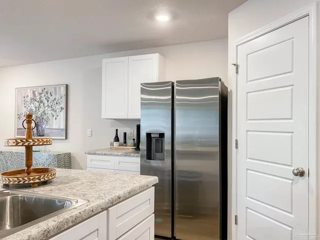 a kitchen with stainless steel appliances granite countertop a refrigerator and a stove