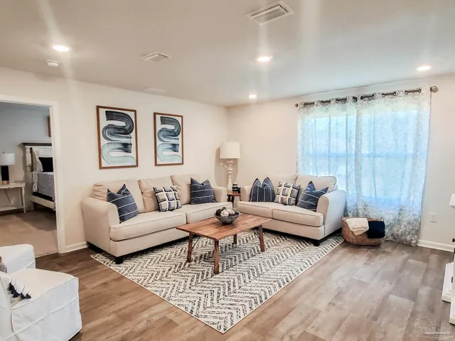 a living room with furniture and wooden floor