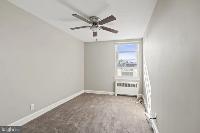 an empty room with closet and windows