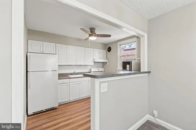a kitchen with stainless steel appliances granite countertop a sink a stove and a refrigerator