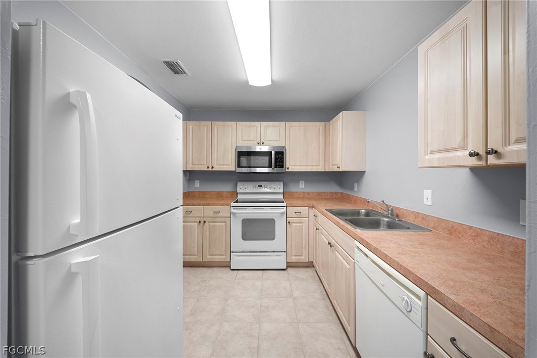 4838 29th Street Southwest Lehigh Acres, FL 33973 - Photo 11 of 25 a kitchen with white cabinets and white appliances
