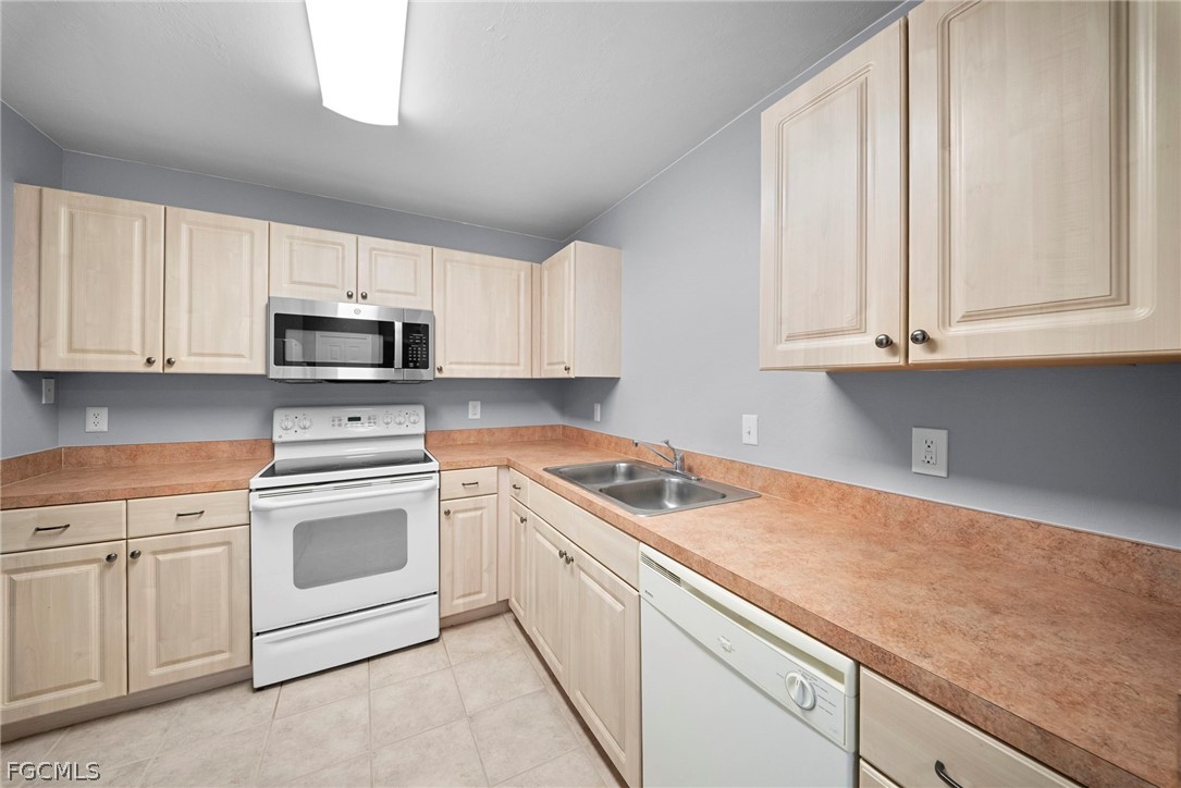 4838 29th Street Southwest Lehigh Acres, FL 33973 - Photo 12 of 25 a kitchen with white cabinets and white appliances