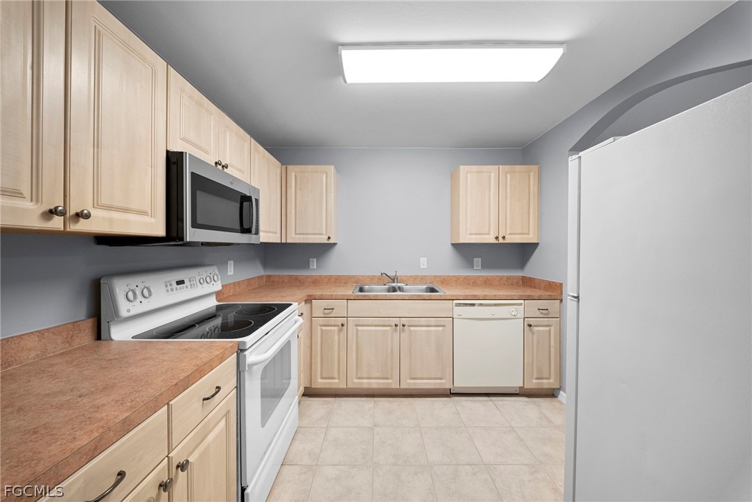 4838 29th Street Southwest Lehigh Acres, FL 33973 - Photo 13 of 25 a kitchen with stainless steel appliances granite countertop a sink and a microwave