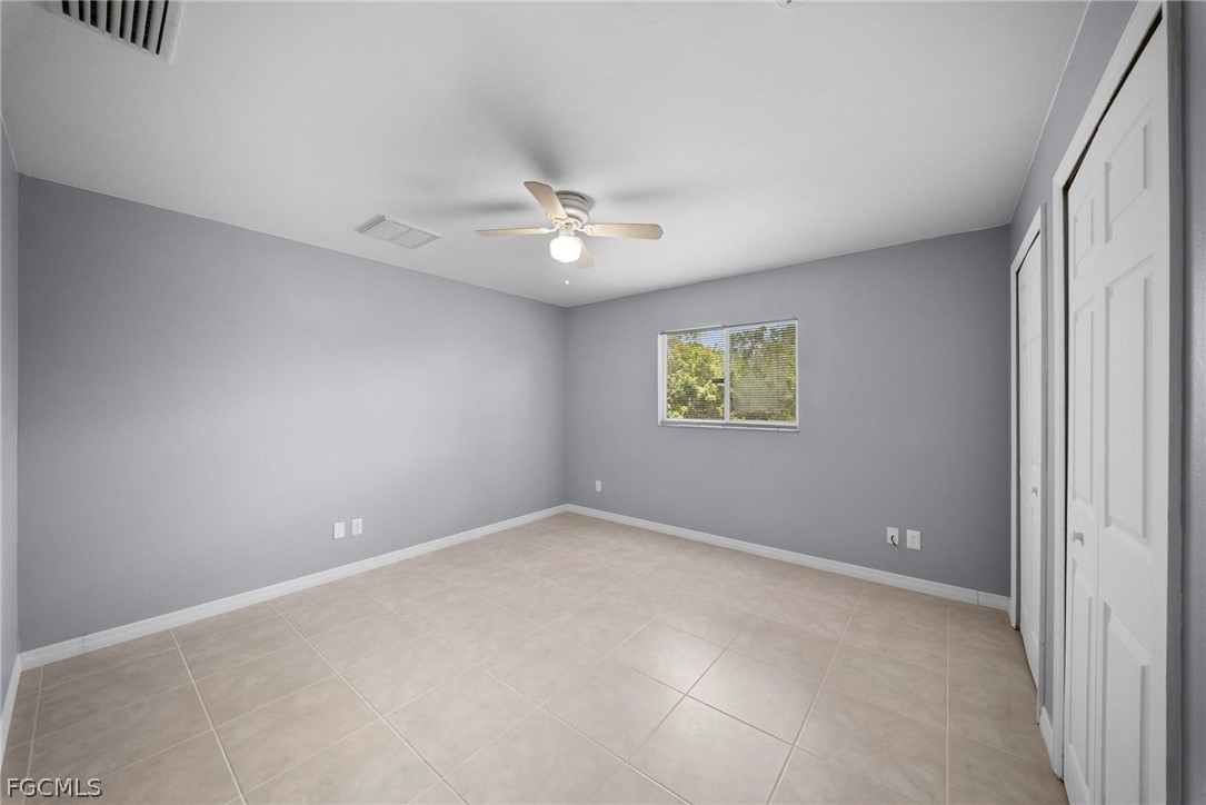 4838 29th Street Southwest Lehigh Acres, FL 33973 - Photo 17 of 25 an empty room with windows and fan