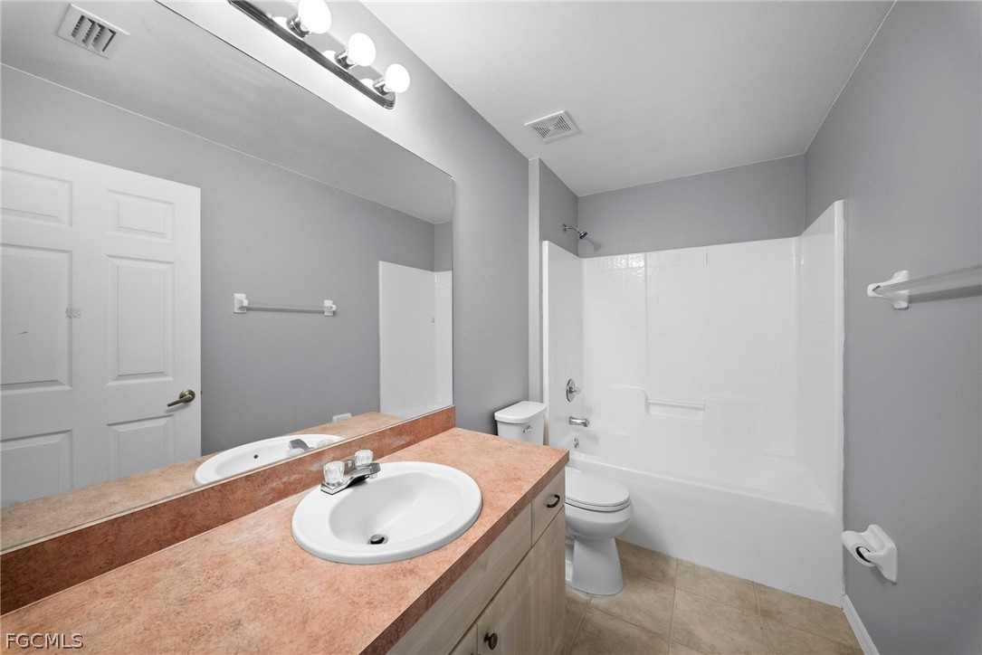4838 29th Street Southwest Lehigh Acres, FL 33973 - Photo 20 of 25 a bathroom with a granite countertop sink a toilet and shower