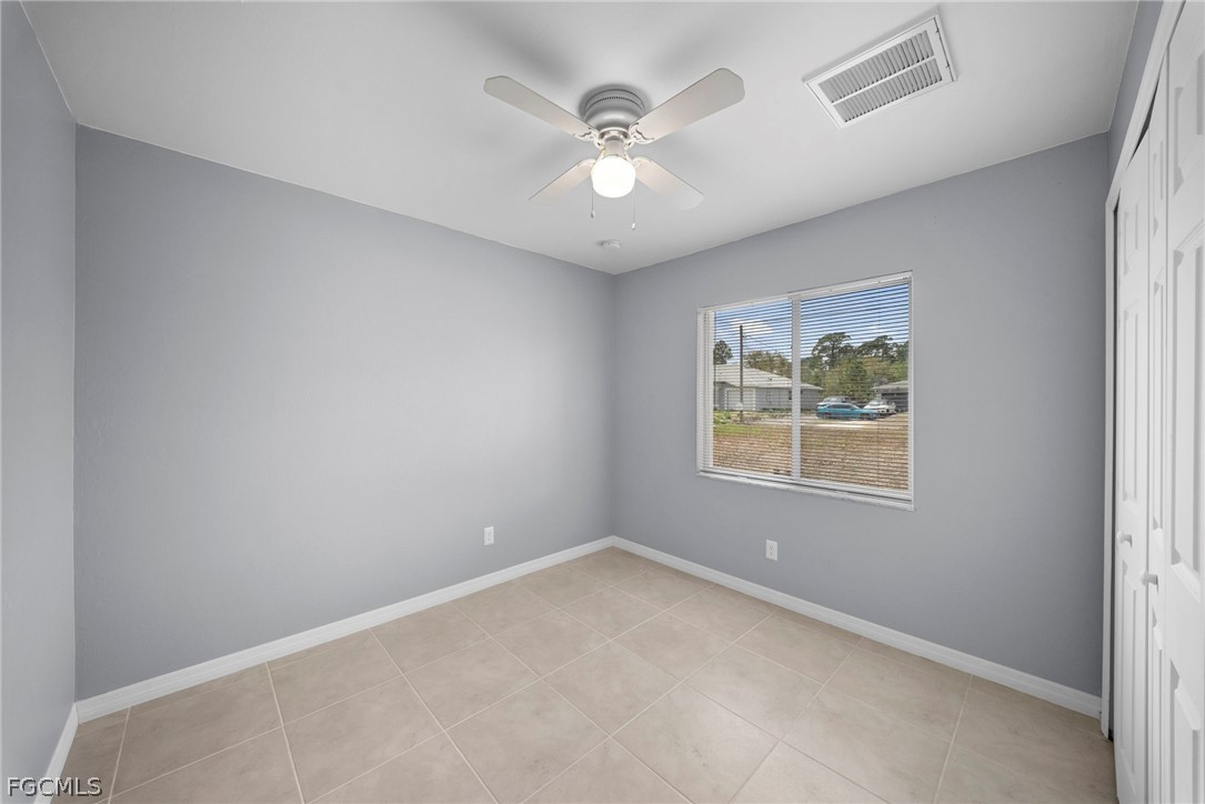 4838 29th Street Southwest Lehigh Acres, FL 33973 - Photo 5 of 25 an empty room with windows and ceiling fan