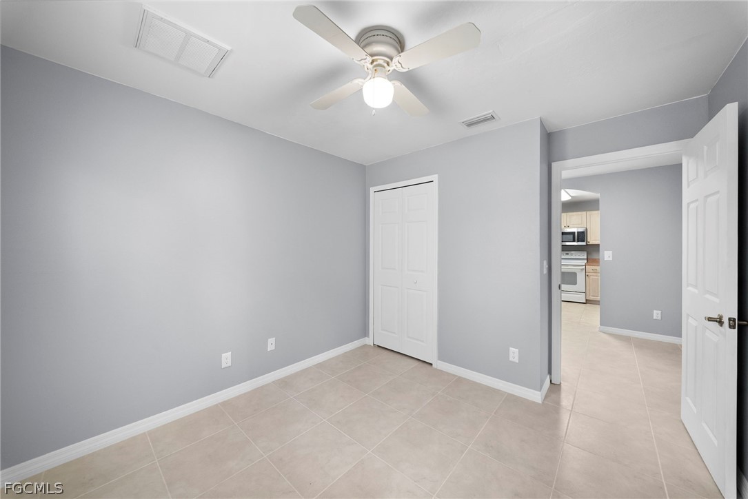 4838 29th Street Southwest Lehigh Acres, FL 33973 - Photo 9 of 25 an empty room with closet and a ceiling fan