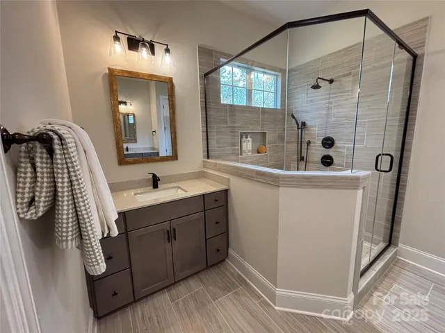 a bathroom with a sink a mirror and shower
