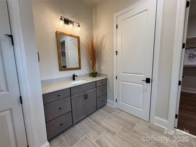 a spacious bathroom with a double vanity sink a mirror and a shower