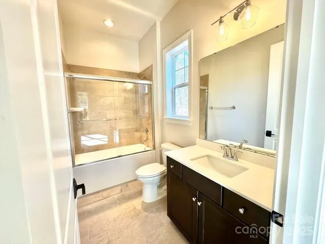 a bathroom with a sink vanity mirror and toilet