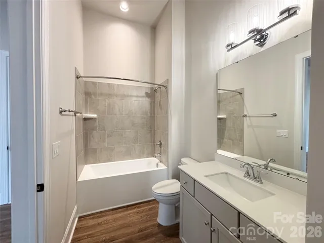 a bathroom with a granite countertop tub toilet a sink and a mirror