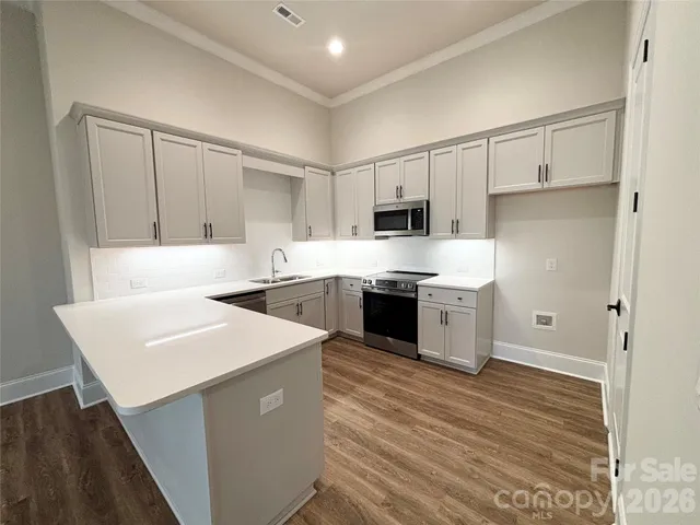 a kitchen with stainless steel appliances a white stove top oven sink and cabinets