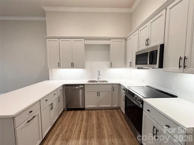 a kitchen with granite countertop white cabinets and white appliances