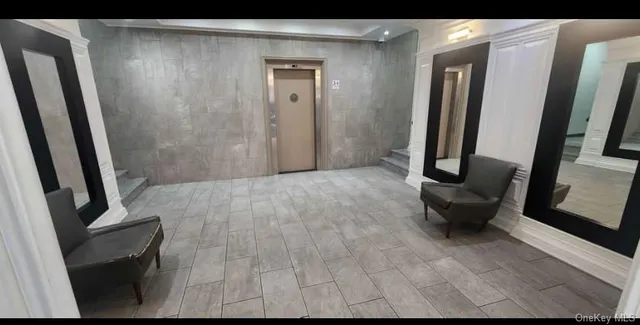 a view of a hallway with furniture and a mirror