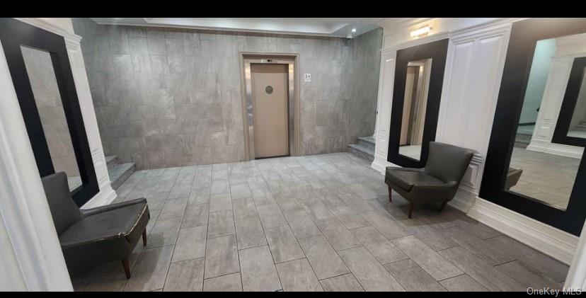 a view of a hallway with furniture and a mirror