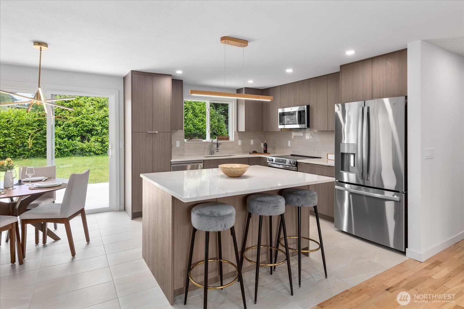 10646 Southeast 236th Street Kent, WA 98031 - Photo 6 of 20 a kitchen with stainless steel appliances granite countertop a table chairs refrigerator and sink