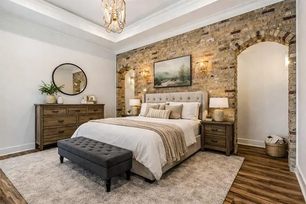 a bedroom with a bed a mirror and dresser