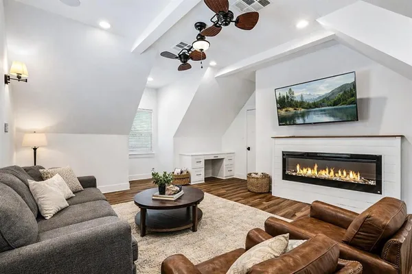 a living room with furniture a flat screen tv and a fireplace