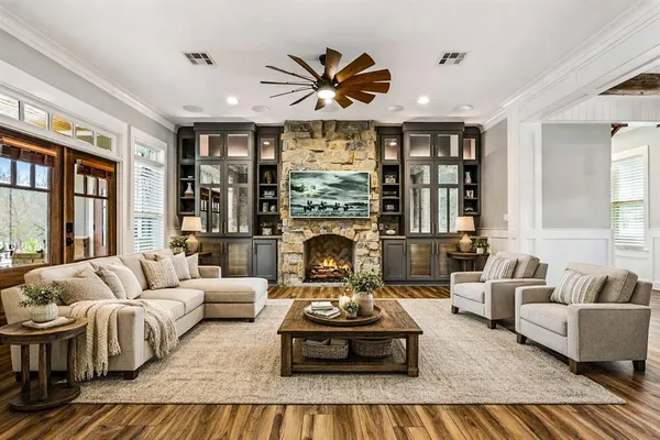 a living room with furniture fireplace and large windows