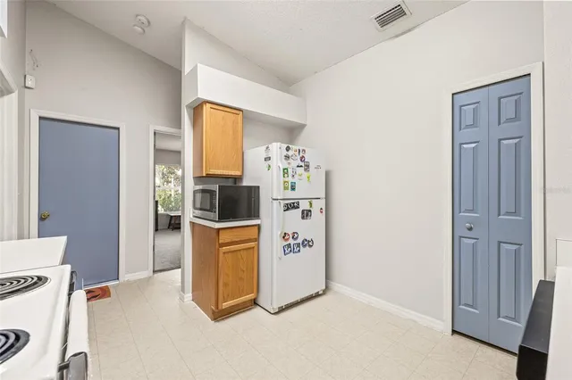 a utility room with fridge dryer and washer