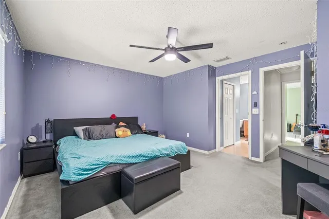 a bedroom with a bed and ceiling fan
