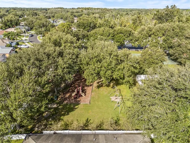 a view of the house with a big yard and large trees