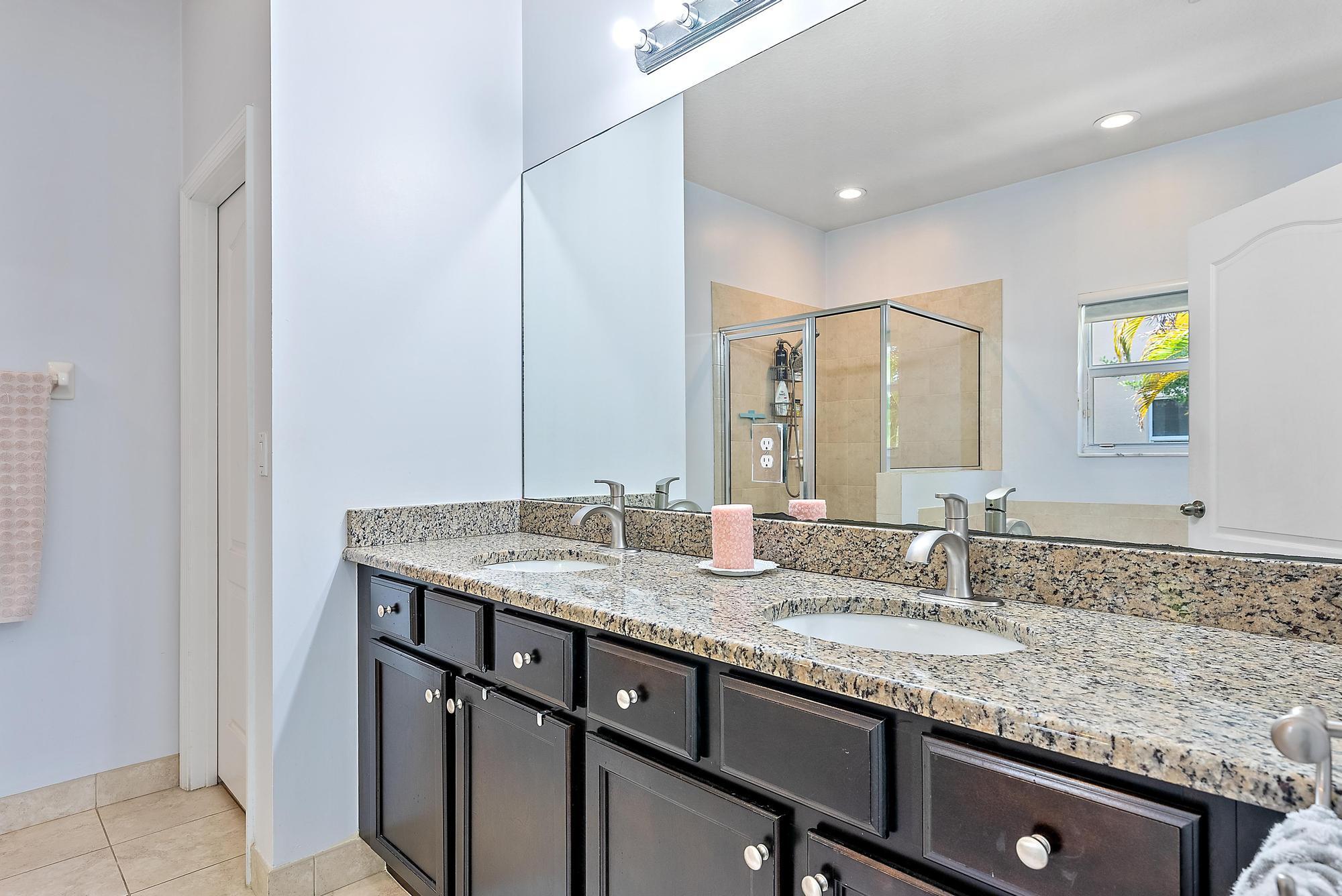 119 Whale Cay Way Jupiter, FL 33458 - Photo 12 of 46 a bathroom with a granite countertop sink and a mirror