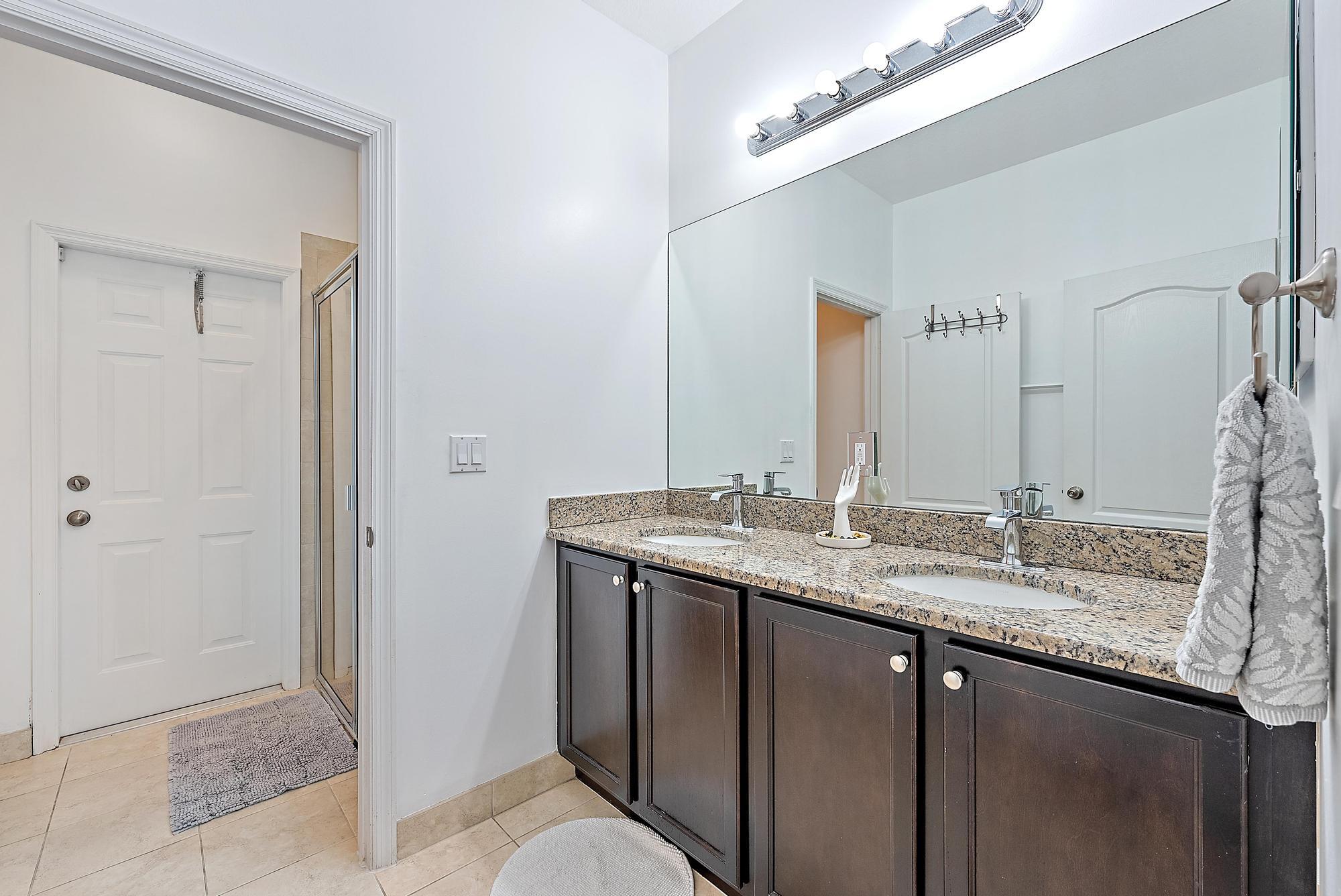 119 Whale Cay Way Jupiter, FL 33458 - Photo 16 of 46 a bathroom with a granite countertop sink and a mirror