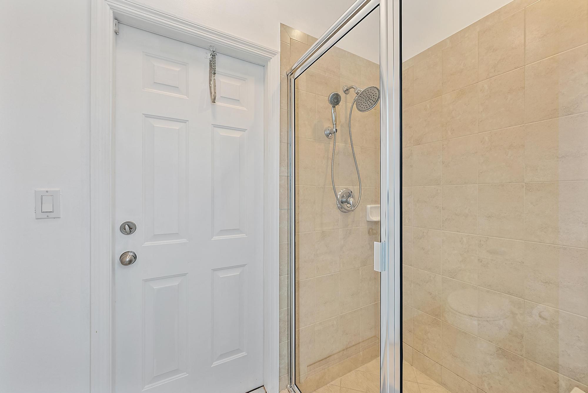 119 Whale Cay Way Jupiter, FL 33458 - Photo 17 of 46 a bathroom with a glass shower door