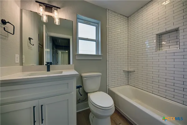 a bathroom with a sink a toilet and shower