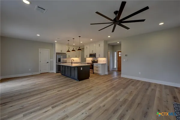a view of a kitchen with a sink and wooden floor