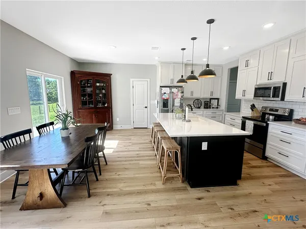 a kitchen with a table chairs sink and cabinets